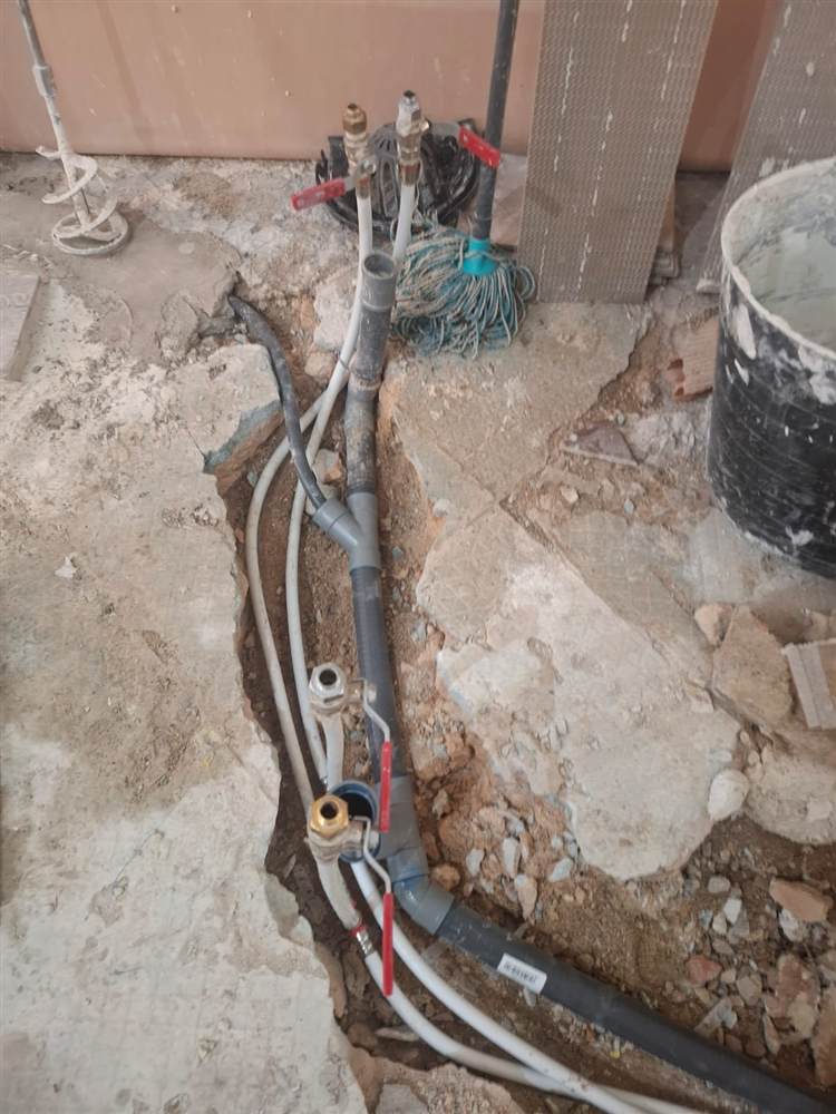 Instalación de tuberías de fontanería bajo suelo en una reforma de baño