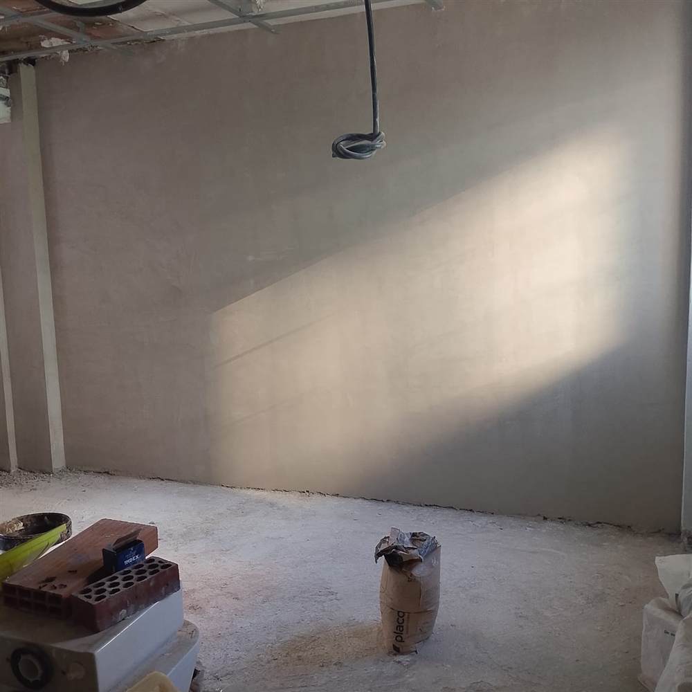 Pared interior enfoscada y lista para acabado en una reforma integral de vivienda